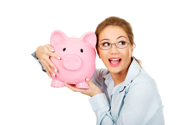 Woman holding piggy bank. - Фото, зображення