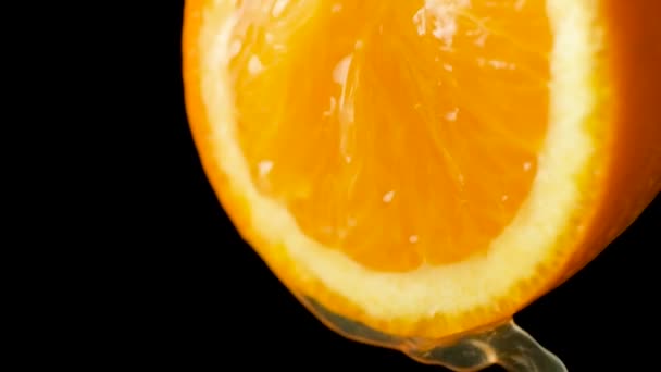 Macro proces knijpen sinaasappelsap uit een halve verse sinaasappel, slow motion - Video