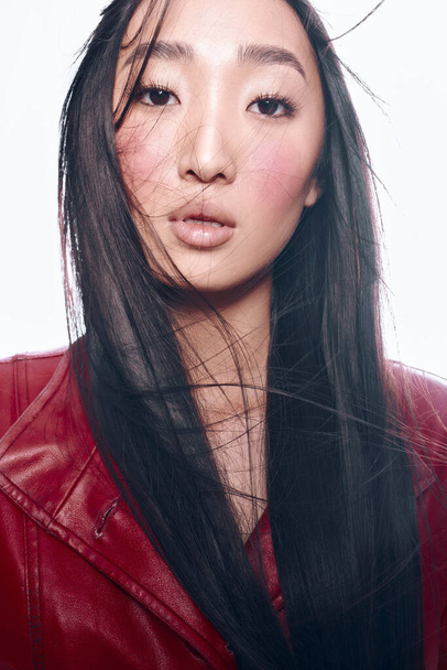 都市の設定で写真撮影のための長い黒い髪と赤いジャケットを持つスタイリッシュな女性 - 写真・画像