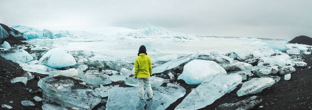 Близько до лагуни льодовика Фіаллшокулл з людиною стоїть на айсберзі. Чудова льодовикова лагуна Фіалльдерн в Ісландії тане - Фото, зображення