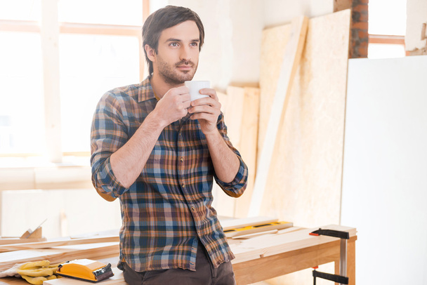 Thoughtful carpenter holding coffee cup - Zdjęcie, obraz