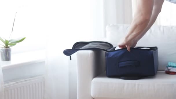 bliska człowieka pakowania ubrań do torby podróżnej - Materiał filmowy, wideo