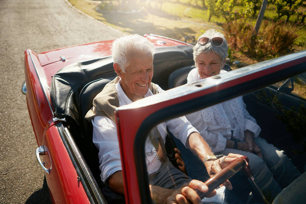 Senior, couple and road or driving convertible for retirement date or holiday adventure, vineyard or transportation. Man, woman and old people in luxury car in California for morning, travel or relax. - Photo, image