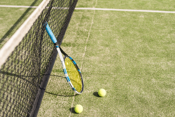 Tennis racquet and tennis balls at the net on the lines on a tennis court. . High quality photo - Photo, Image