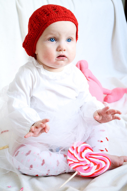 ένα χαριτωμένο κοριτσάκι σε κόκκινο καπέλο - Φωτογραφία, εικόνα