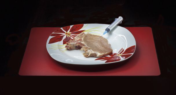 Concepto organismo modificado genéticamente: jeringa y carne
 - Foto, Imagen
