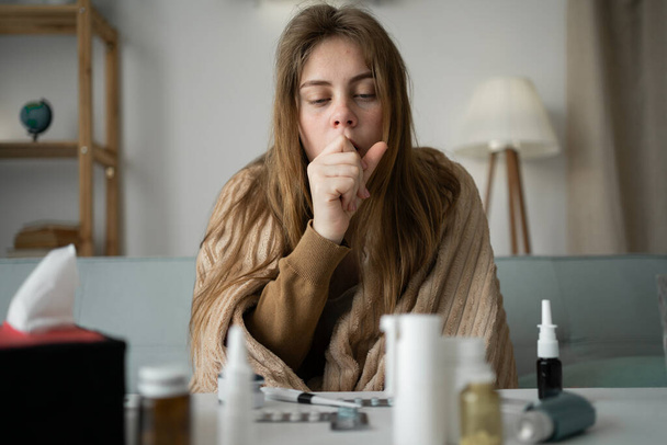 jovem doente chateado mulher sentado no sofá em casa coberto com um cobertor tosse intensamente, menina doente com sintomas de gripe, - Foto, Imagem