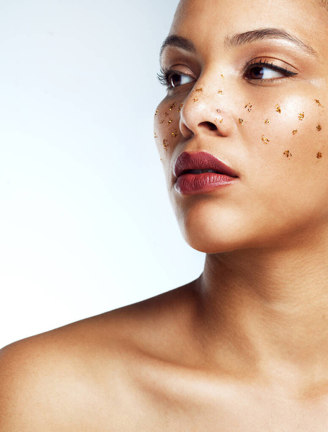 Skincare, woman and face with glitter freckles for elegant makeup aesthetic and dermatology isolated in studio. Female person or model and beauty with facial cosmetics for luxury sparkle or shine. - Photo, Image