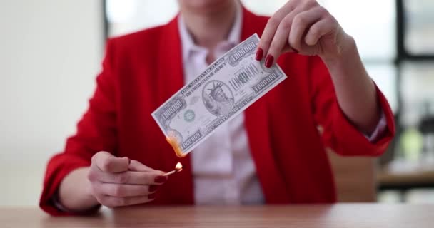 La mujer de negocios vestida con ropas formales rojas prende fuego a un billete falso de un millón de dólares con fósforos y mira al fuego. Fallos financieros y contenido de la quiebra - Metraje, vídeo