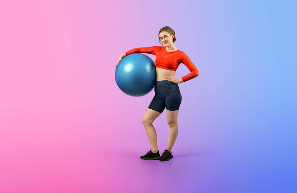 Full body length gaiety shot athletic and sporty young woman with fitness exercising ball in standing posture on isolated background. Healthy active and body care lifestyle. - Foto, Imagen