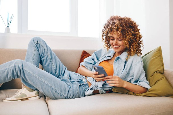 Happy Woman Holding Phone, Relaxační na útulné pohovce v obývacím pokoji - Fotografie, Obrázek