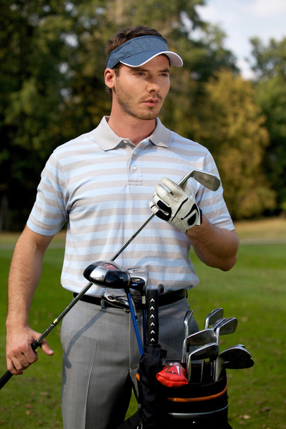 man standing by golf bag - Фото, зображення