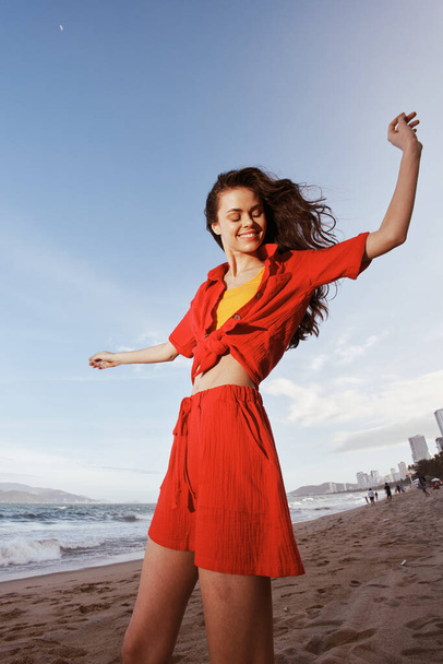 Mujer sonriente bailando con alegría en la playa soleada - Foto, imagen