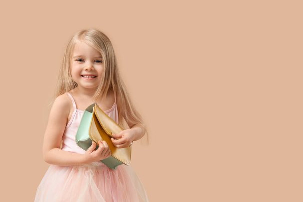 Cute little girl with stylish bag on brown background - Φωτογραφία, εικόνα