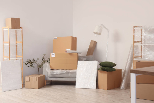 Boîtes mobiles avec meubles enveloppés dans le salon - Photo, image