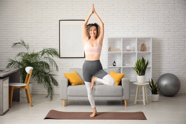 Happy mature sporty woman practicing yoga at home - Zdjęcie, obraz