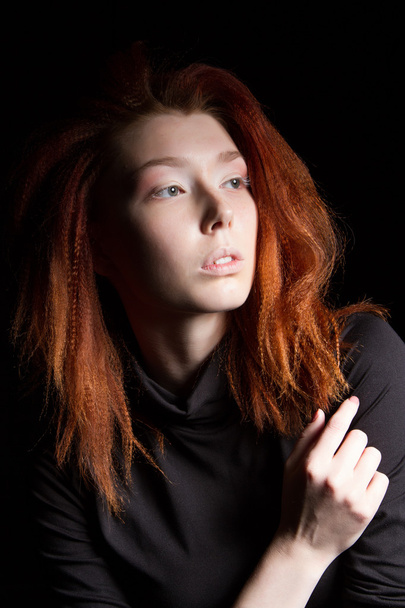 The girl with red hair on a black background - 写真・画像