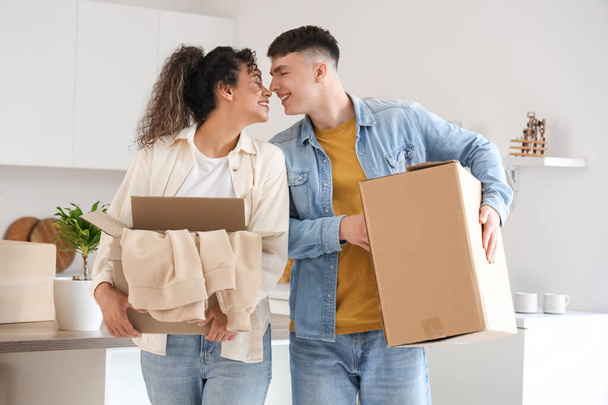 Happy young couple with moving boxes at new home - Fotografie, Obrázek