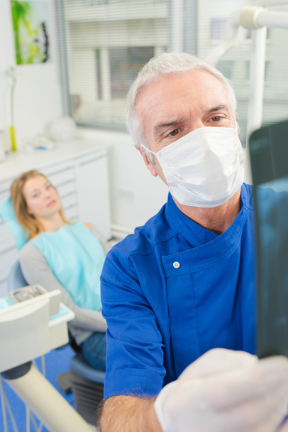Dentist looking at an x-ray - Photo, image