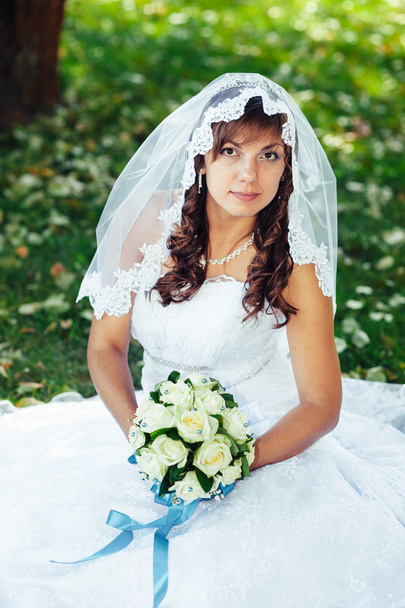 Portrait of a beautiful smiling bride posing in her wedding day - Фото, изображение