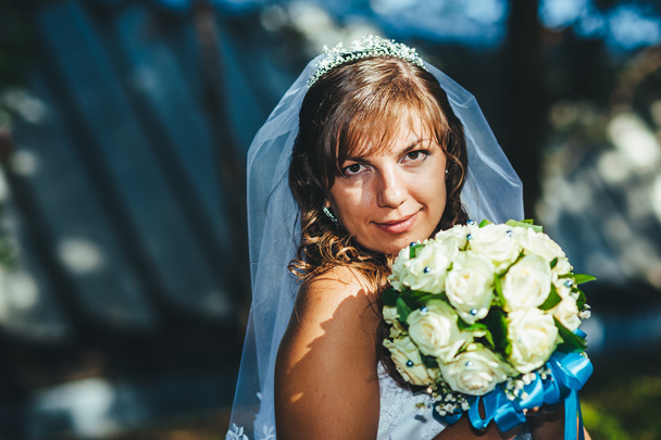 Portrait of a beautiful smiling bride posing in her wedding day - Fotó, kép