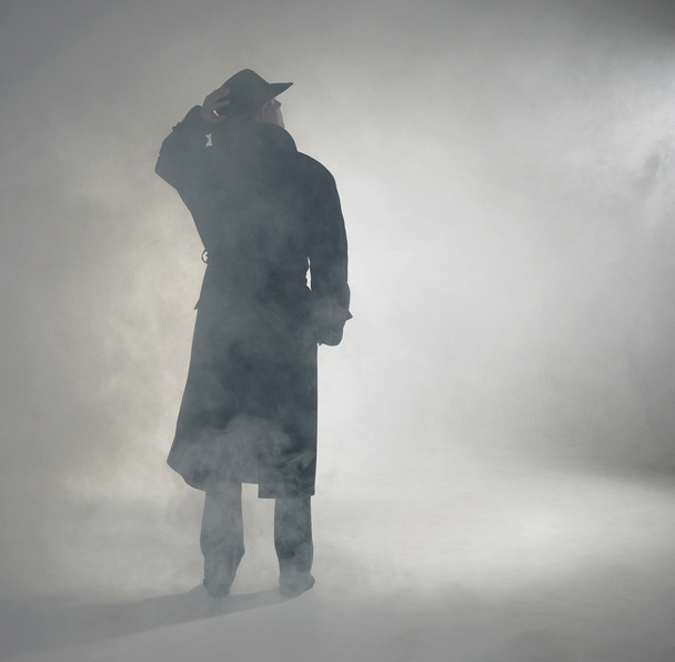 Mulher vestindo casaco de trincheira e de pé no nevoeiro
 - Foto, Imagem