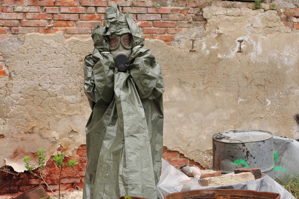 Man met gas masker en groene militaire kleding na chemische ramp. - Foto, afbeelding