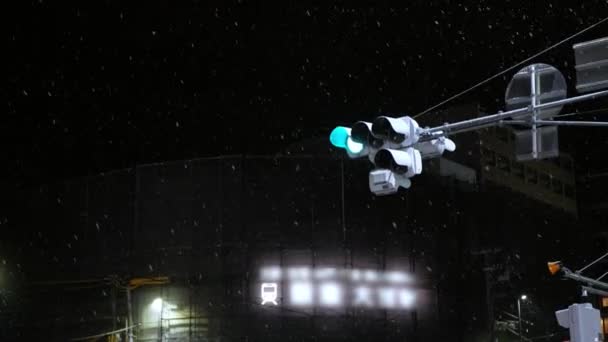 kilátás a közlekedési lámpa utcai kereszteződésben éjszaka, miközben enyhén havazik, közlekedési város éjszakai élet utcára néző város modern Kiotó - Felvétel, videó