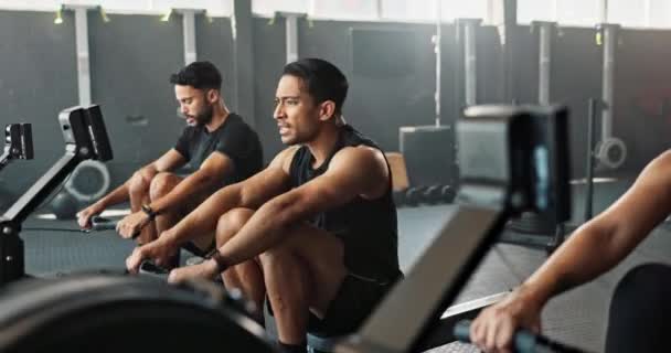 Workout, rowing machine and friends in gym for energy, wellness or sports for body health. Club, group and people exercise on ergometer for fitness, muscle and cross training for cardio together. - Footage, Video