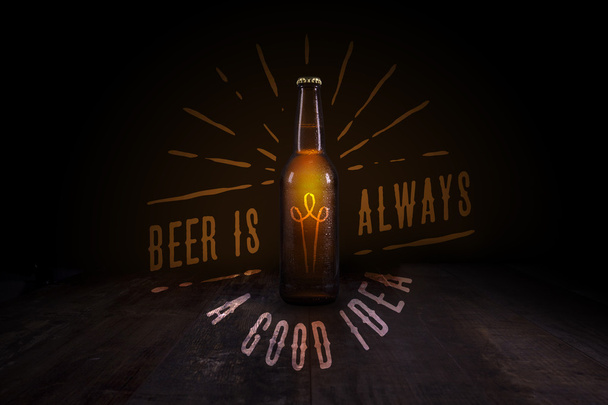 Beer bottle on a rustic table with beer related quote - 写真・画像