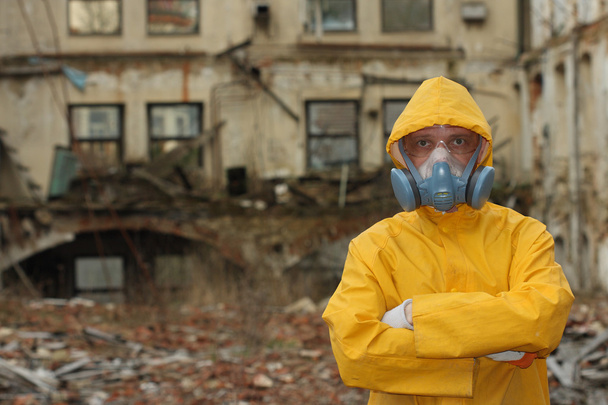 Άνθρωπος με προστατευτική μάσκα και προστατευτικά ρούχα διερευνά επικίνδυνη περιοχή - Φωτογραφία, εικόνα