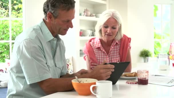 Pareja mirando la tableta digital durante el desayuno
 - Metraje, vídeo
