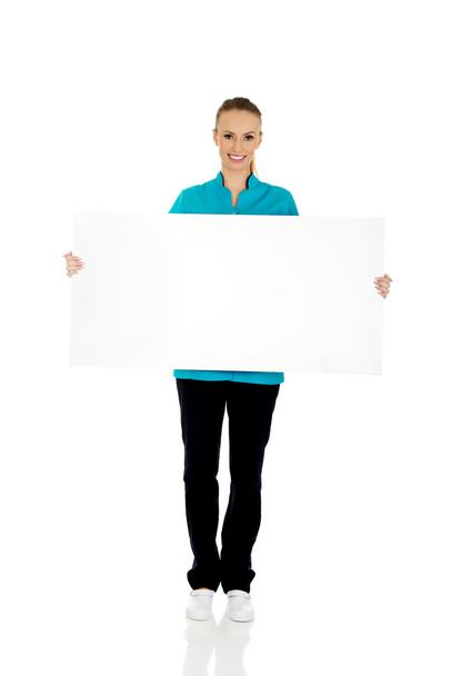 Female doctor holding placard. - Zdjęcie, obraz