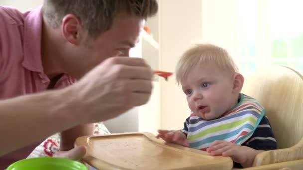 father feeds infant son - Imágenes, Vídeo