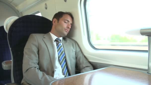 Businessman sleeping on train journey - Кадры, видео