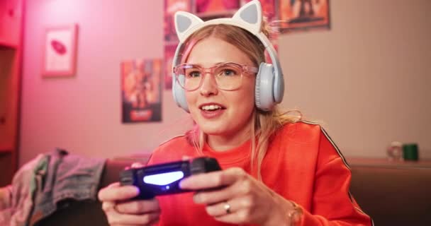 Fun, gen z gamer or controller to play, video game or esports on sofa as excited, virtual challenge. Intense, young woman or couch on tech to focus, solve or level up in online gaming competition. - Footage, Video