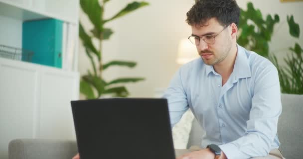 Biznesmen skoncentrowany na odpowiedzi na e-maile na swoim laptopie - Materiał filmowy, wideo