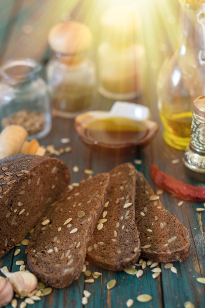 Ayçiçeği tohumları üzerinde ahşap bir masa ile geleneksel karanlık ekmek. - Fotoğraf, Görsel