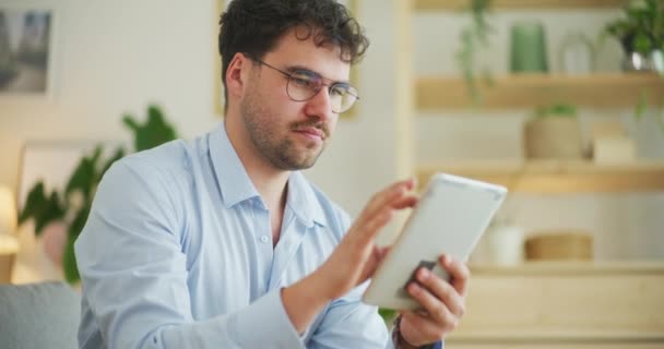 Un hombre hace una compra a través de aplicaciones en línea en una tableta digital - Imágenes, Vídeo