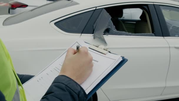O inspetor do homem examina o dano do carro documentando o papel dos inspetores notação de dano avaliação de danos da perícia automotiva. Inspector examina danos de veículos fazendo anotações detalhadas documentação - Filmagem, Vídeo