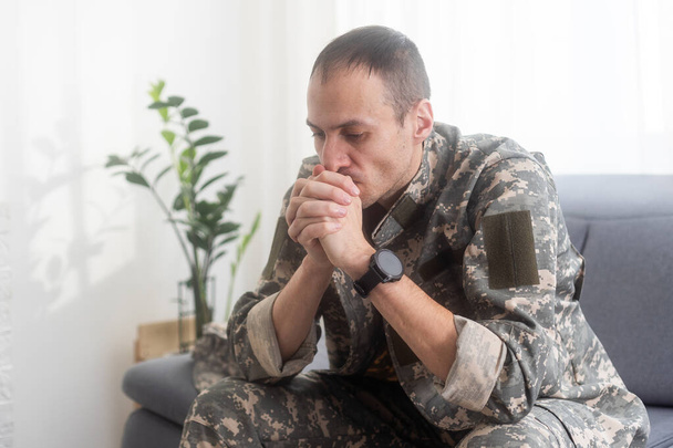 Hombre nervioso militar sufriendo depresión, sentado solo en casa, concepto de estrés postraumático. Foto de alta calidad - Foto, imagen