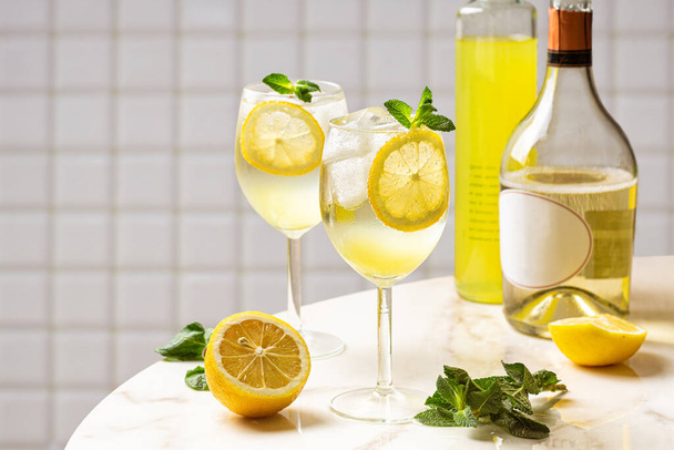 Limoncello Spritz koktajl, wspaniałe połączenie limoncello, wino musujące i soda z cytryną, lód i mięta. Włoski letni drink. Białe tło. - Zdjęcie, obraz