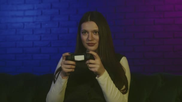 Концепція залежності від відеоігор. Доросла молода жінка спокійно грає з джойстиком. Орієнтована на гру, леді грає в режимі сюжету на ігровій станції, використовуючи бездротовий джойстик з вібраціями. Висока якість 4k - Кадри, відео