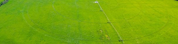 Panorama centrum otočné zavlažování na velkých zemědělských travnatých porostech ve Fairlandu, Oklahoma, nerezová ocel potrubí s pojízdným kufrem motorizované kola umožňující potrubí pohybovat polem, letecký výhled. USA - Fotografie, Obrázek