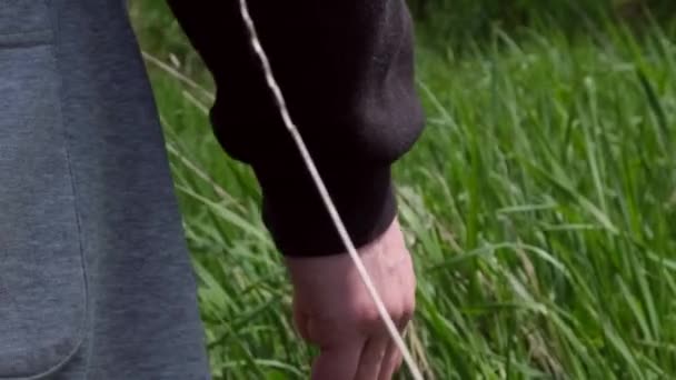 Un ragazzo o un uomo corre la mano lungo l'erba verde che cresce sul campo, andando in lontananza, il concetto di libertà, liberazione dalla dipendenza o relazione. Filmati 4k di alta qualità - Filmati, video