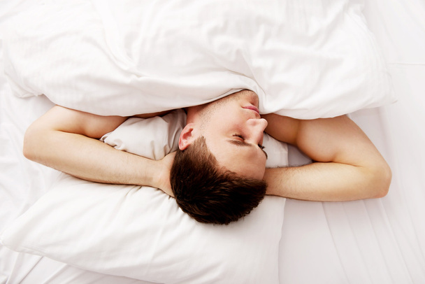Handsome young man lying in bed. - Φωτογραφία, εικόνα