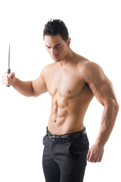 Muscular young man holding big knife ready to stab - Фото, изображение