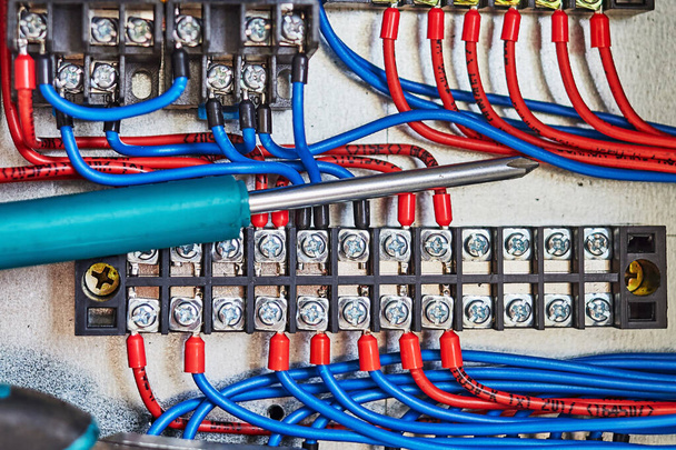 electrical tools and blue wires connected to the contact strip and relays. - Photo, Image