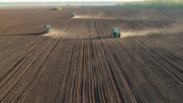 Semillas para sembrar. Tractor arando con taladros de semillas y sembrando la cosecha. drone vuela más allá y baja al suelo - Imágenes, Vídeo