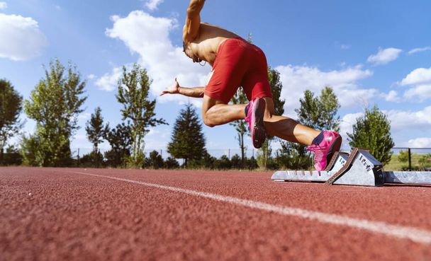 Stadium, man running and start block of athlete on a runner and arena track for sprint - Photo, Image
